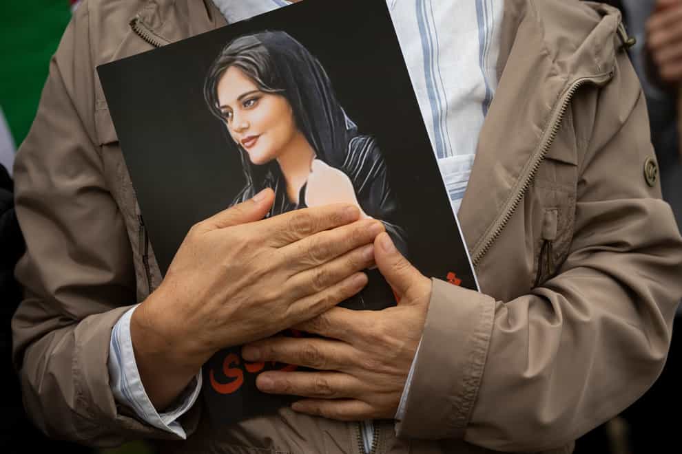 A portrait of Mahsa Amini is held during a rally calling for regime change in Iran in Washington in 2022 (Cliff Owen/AP)
