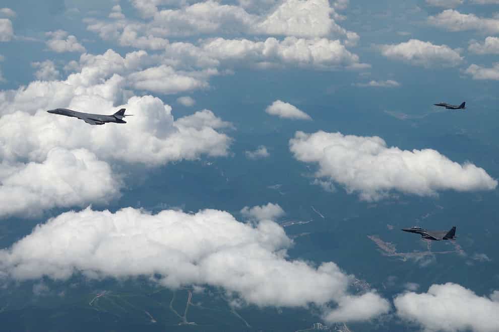 A US Air Force B-1B bomber, left, and South Korean F-15K fighters fly over the Korean Peninsula (South Korea Defence Ministry via AP)