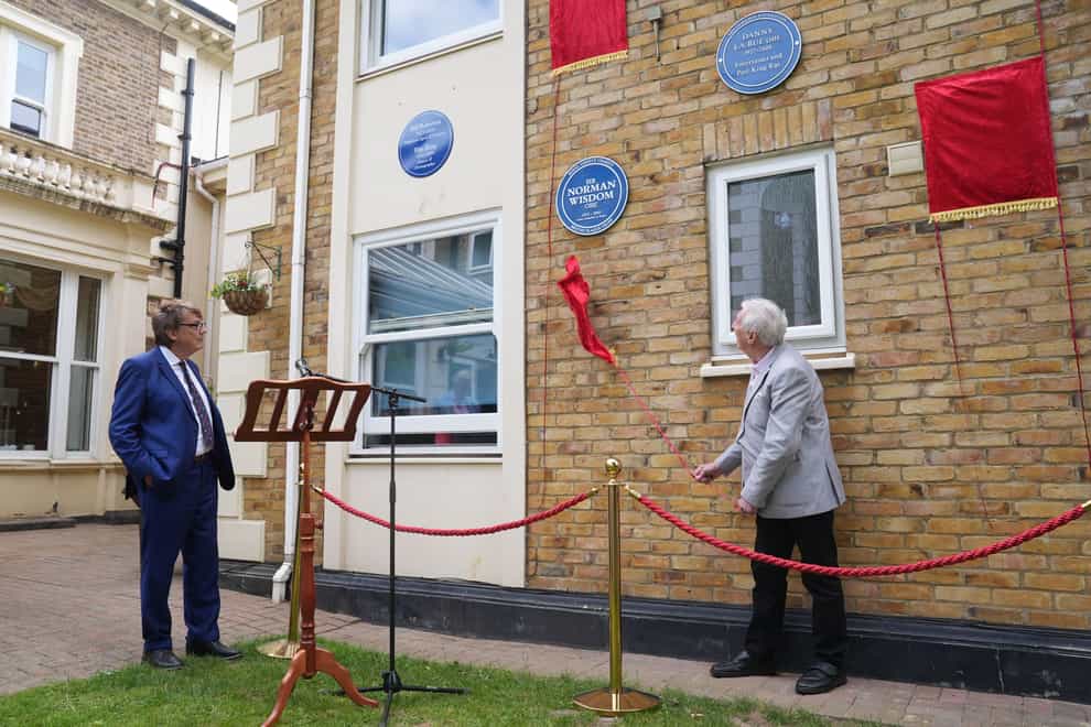 DJ Mike Read watches as Johnny Mans, who represented Sir Norman Wisdom, unveils a Blue Plaque in his name (Lucy North/PA)